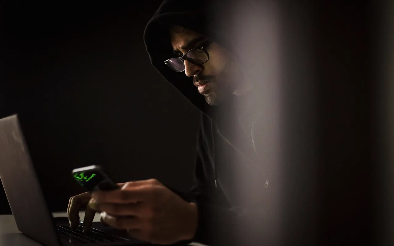 Person holding a phone showing a security warning on the screen
