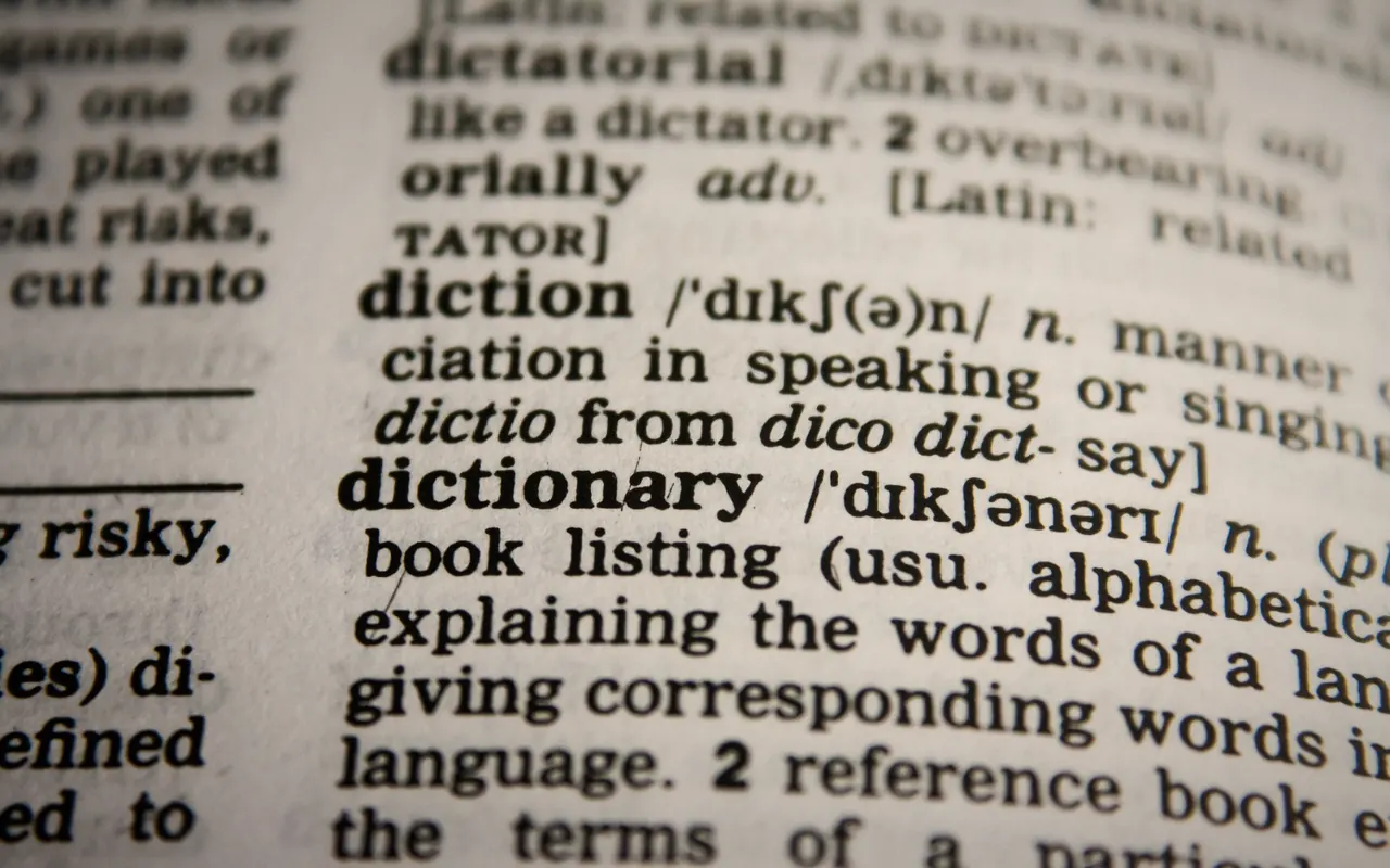 An open dictionary on a table, photographed in low light