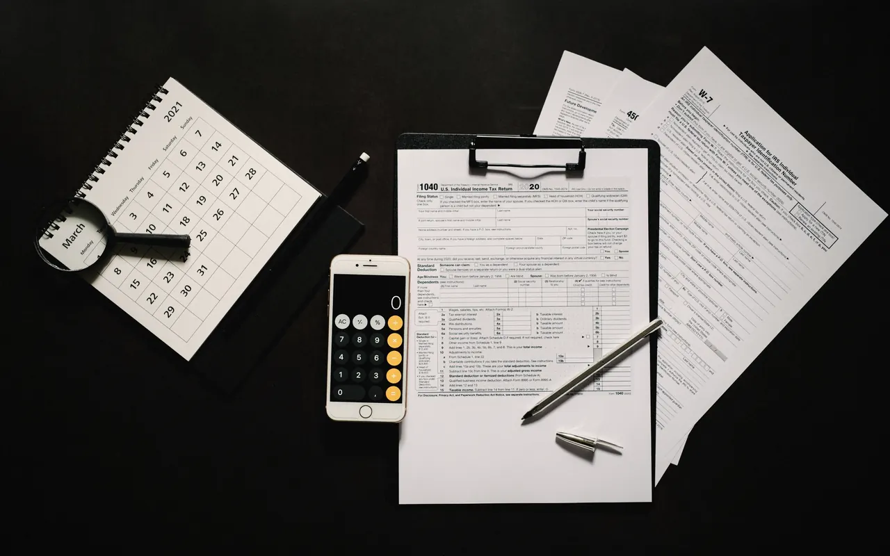 Calculator, documents and a laptop on a desk, ready to prepare an income tax return