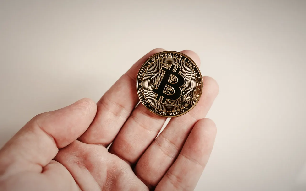 Open hand holding a physical bitcoin coin