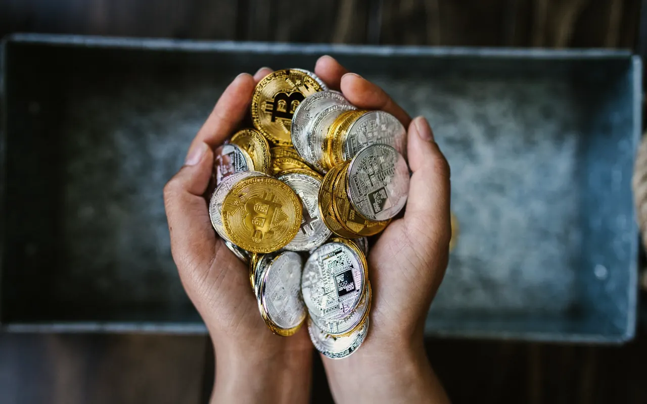 Cryptocurrency coins on a dark desk next to a price chart