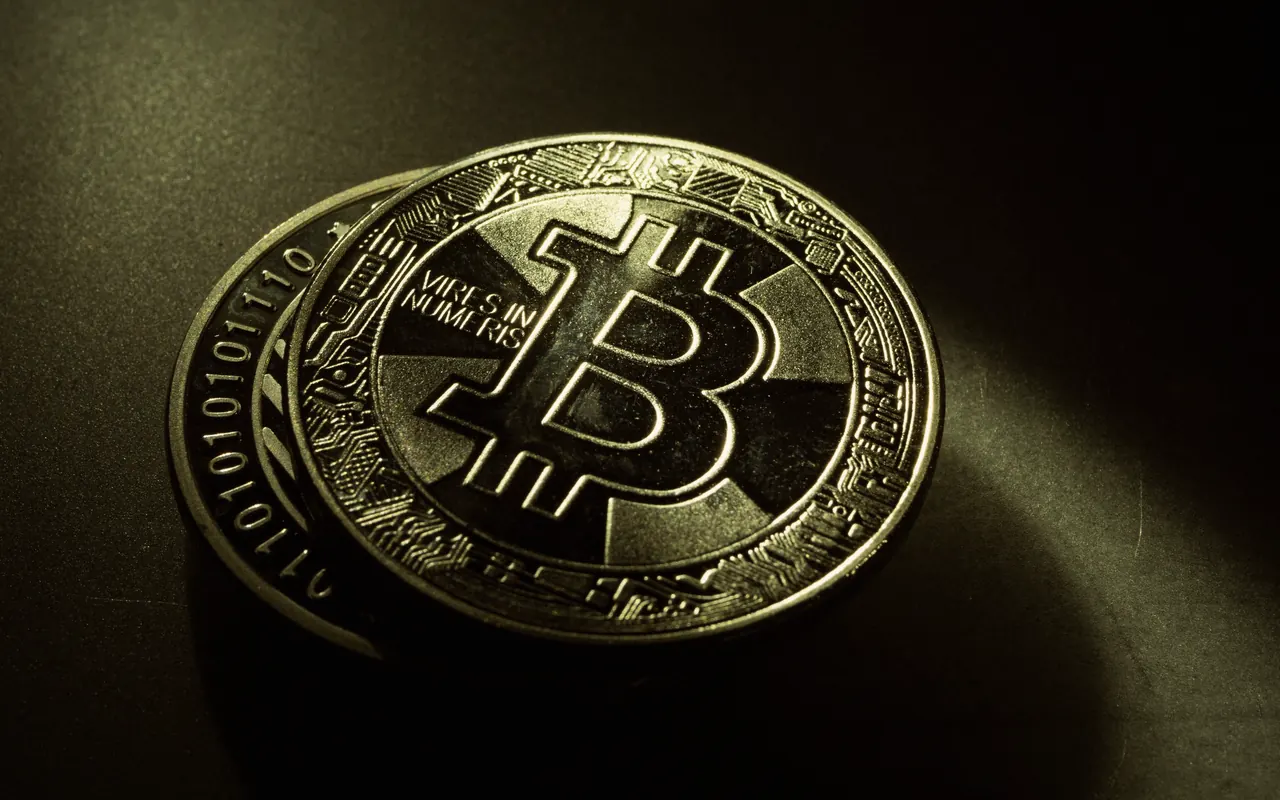 Close-up of a gold coin with the Bitcoin symbol on a dark background
