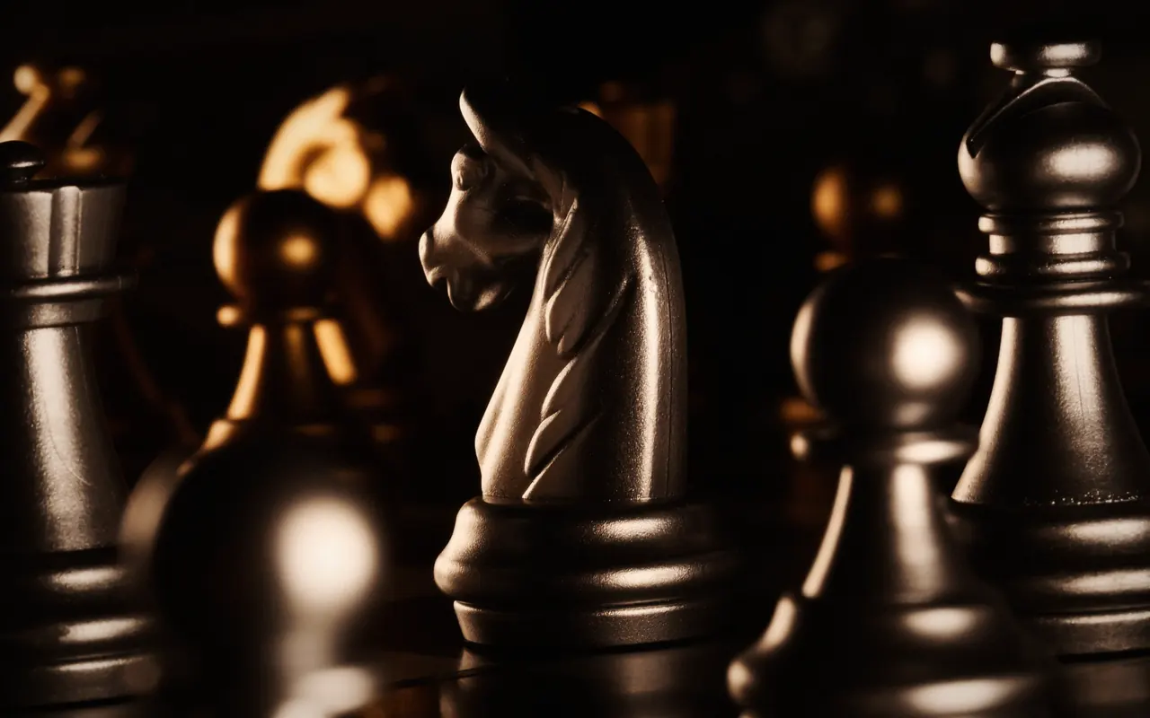 Chess pieces on a board in dim light